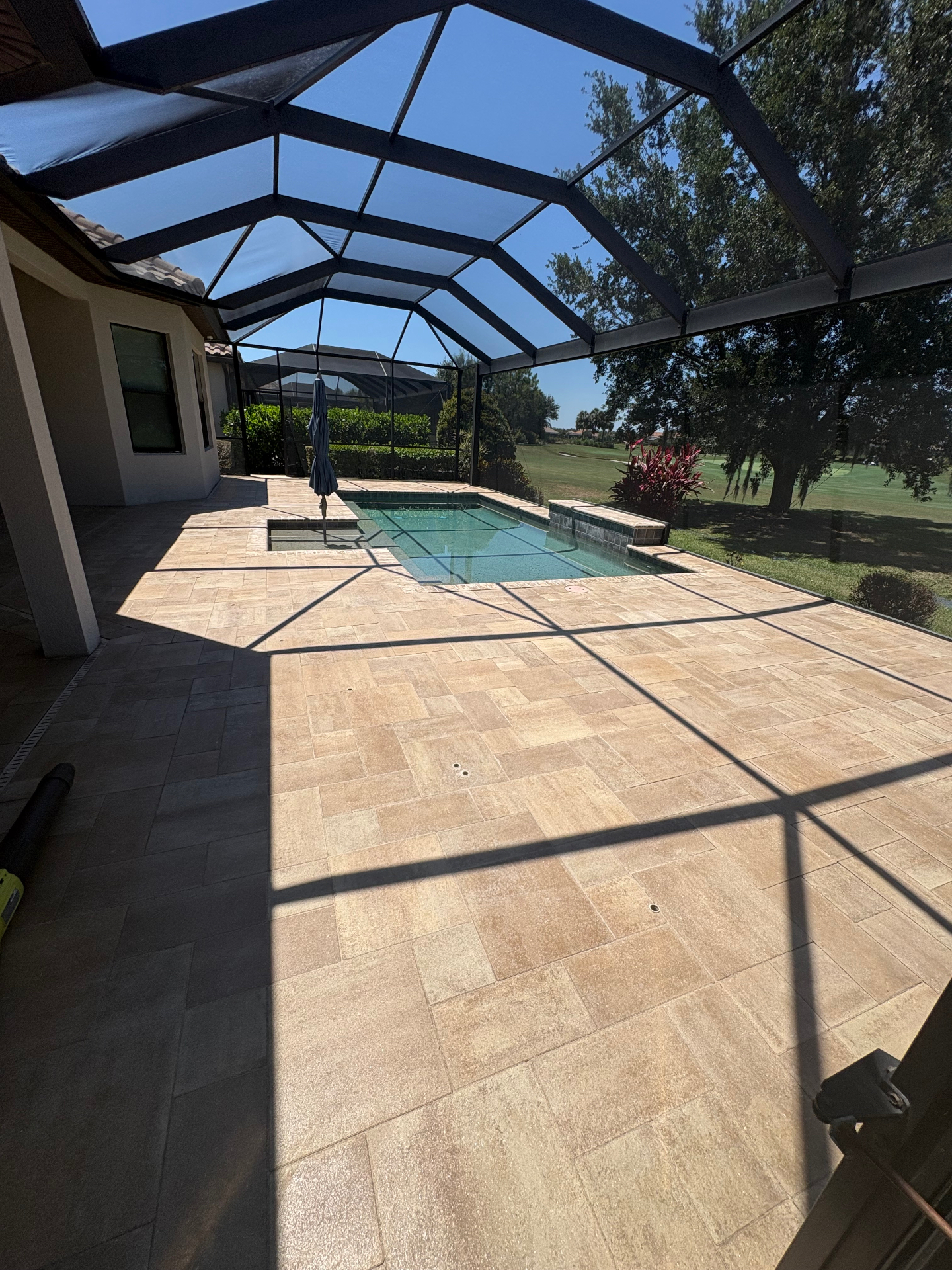 Clean travertine pool deck at a Country Club East home overlooking the golf course