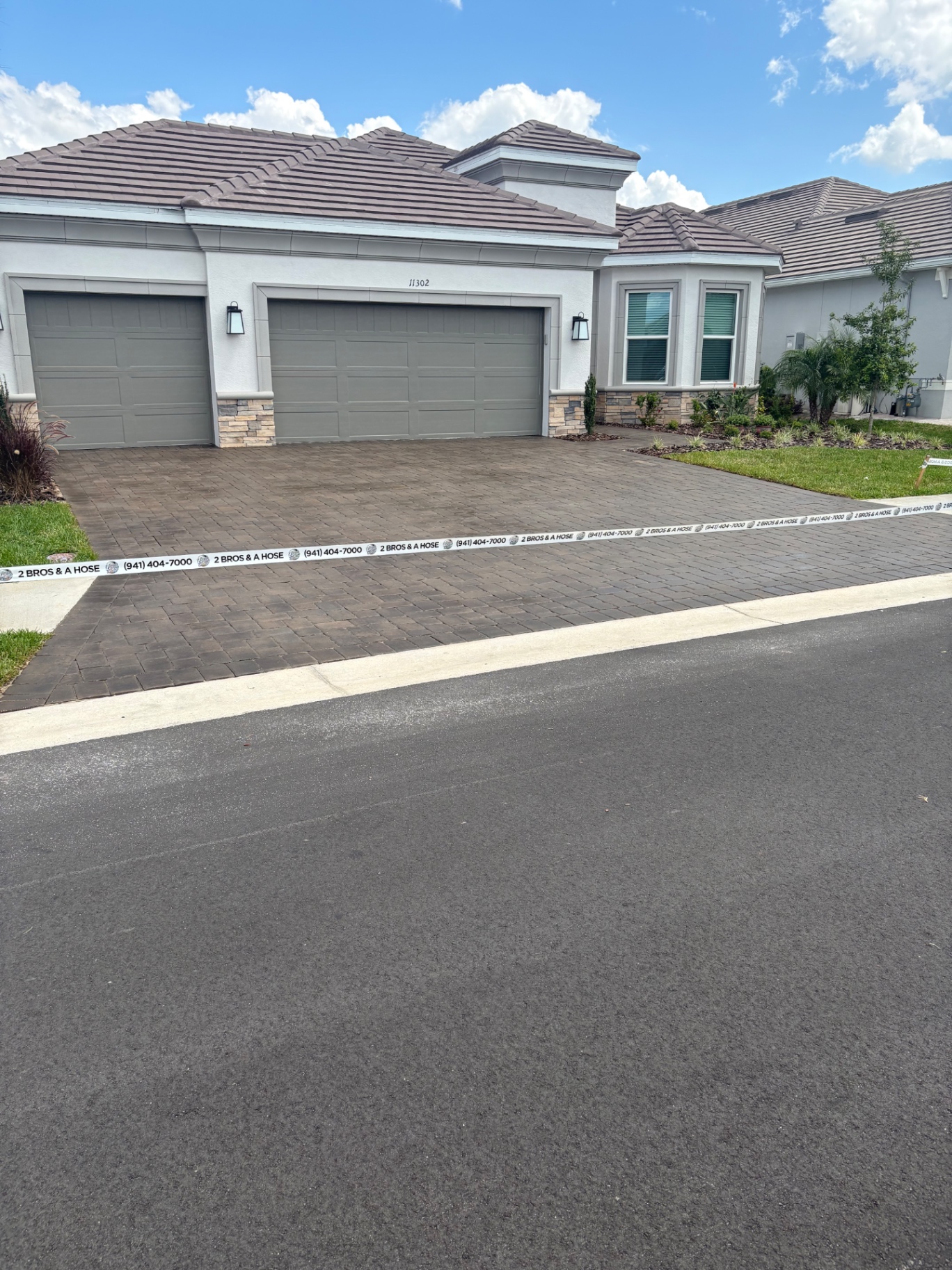 Freshly cleaned gray paver driveway at an Esplanade at Artisan Lakes home in Palmetto